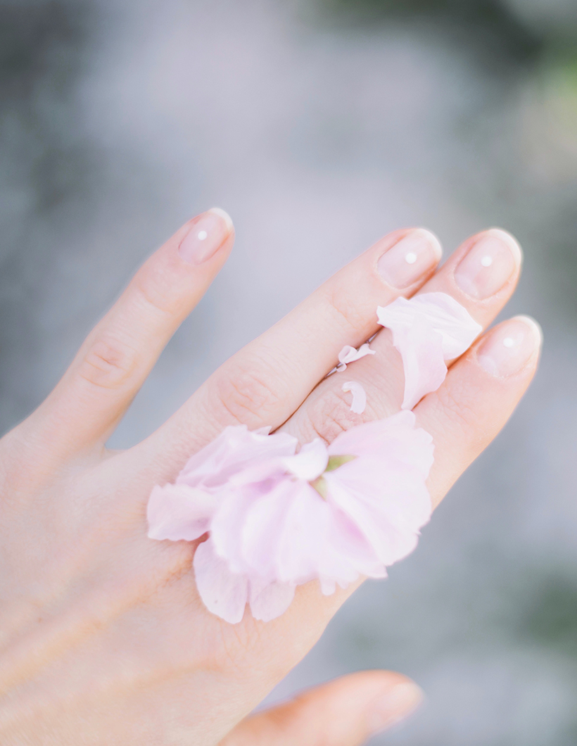 Eine frischmanikürte Hand mit Blüten